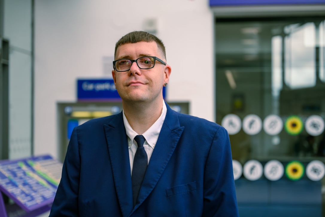 A photograph of Chris Jeffery, a man with short brown hair who is wearing glasses and a dark blue suit and tie with a white shirt.