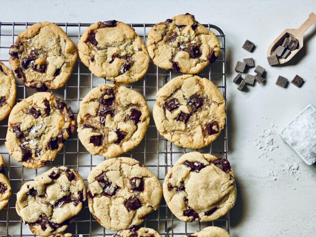 Some chocolate chip cookies cooling on a wire rack.